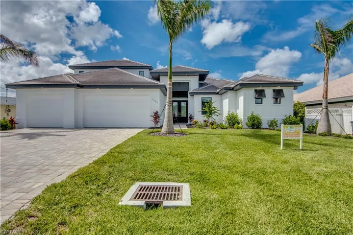Prairie-style home featuring a tile roof, a garage, decorative driveway, and stucco siding