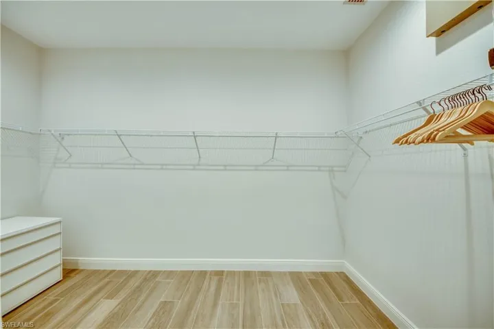 Bathroom with a soaking tub, walk in shower, two vanities, and wood tiled floors