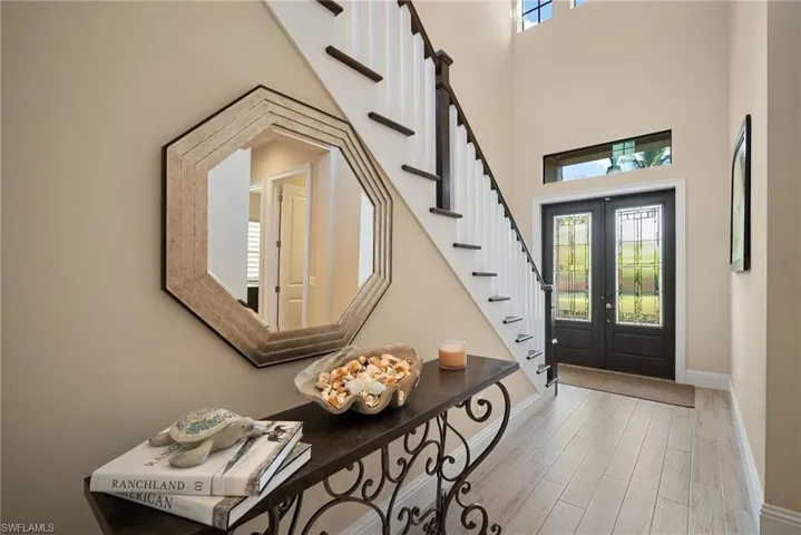 Entrance foyer featuring wood finished floors, french doors, stairs, and a high ceiling