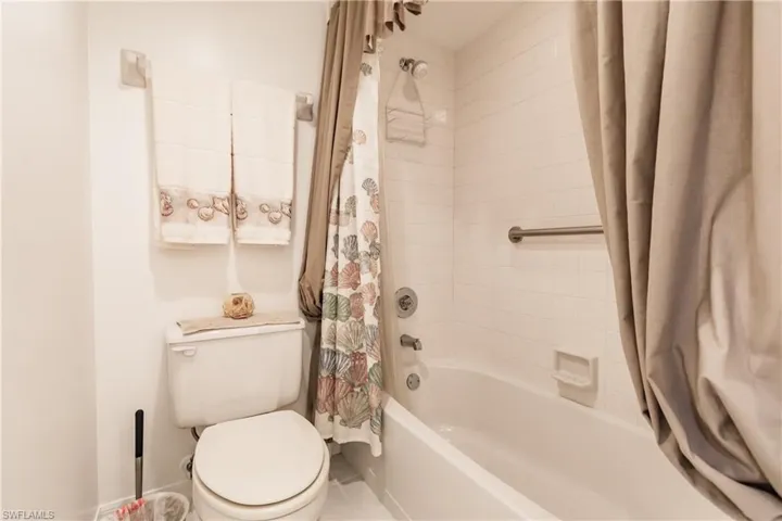 Bathroom with shower / bath combo with shower curtain and toilet