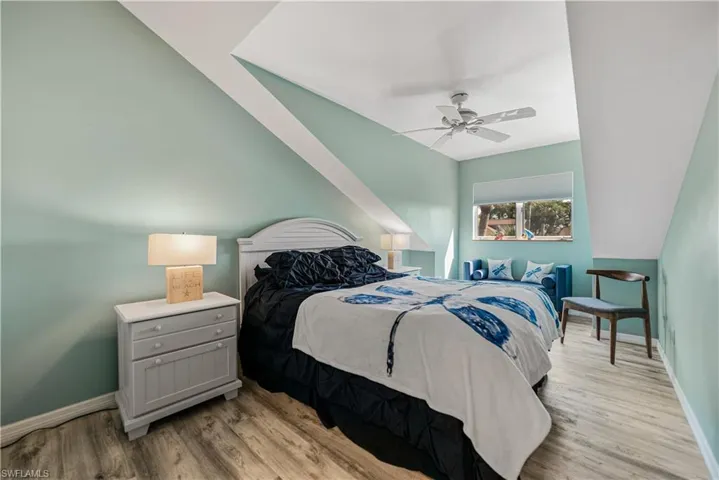 Bedroom 2 with vaulted ceiling, ceiling fan, and LVP. Ensuite Full Bathroom 2 that is shared with Bedroom 3.