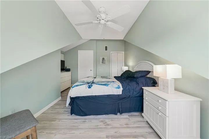 Bedroom 2 with ceiling fan, LVP, and lofted ceiling.