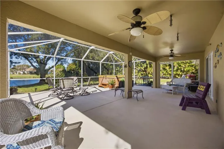 View of patio / terrace featuring a sunroom, a ceiling fan, outdoor furniture, glass enclosure, and a water view