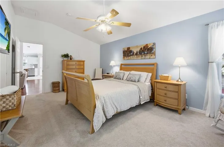 Bedroom featuring a ceiling fan, carpet, and vaulted ceiling