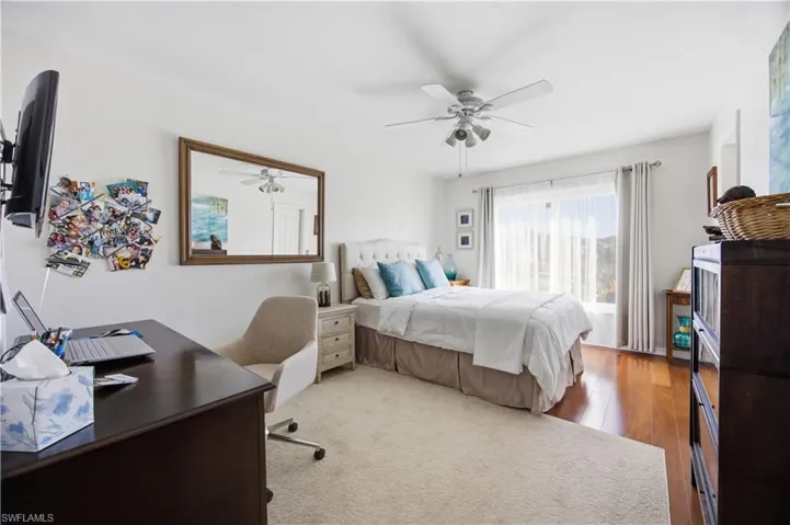 Bedroom featuring light wood-style flooring, ceiling fan, and a desk