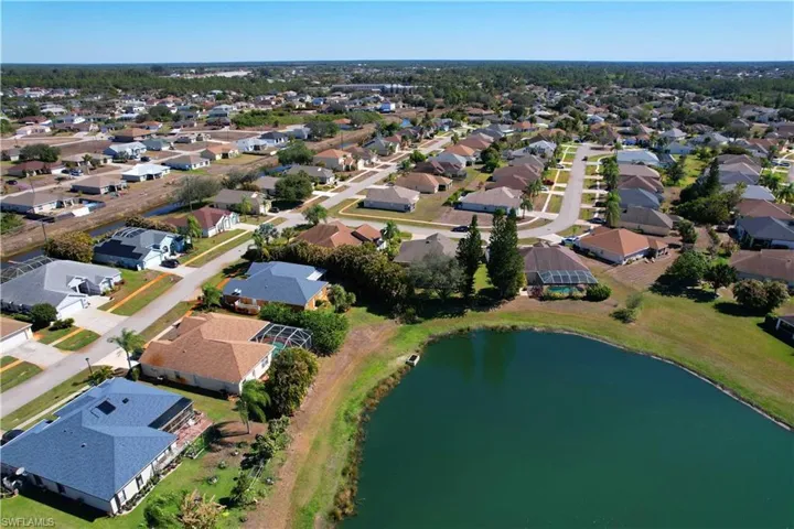Aerial view of property and surrounding area with a large body of water and nearby suburban area