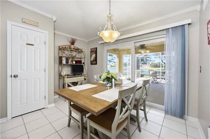 Dining space with crown molding, a ceiling fan, and light tile patterned flooring