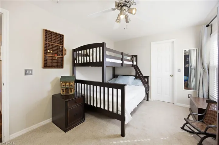 Bedroom with light colored carpet and ceiling fan