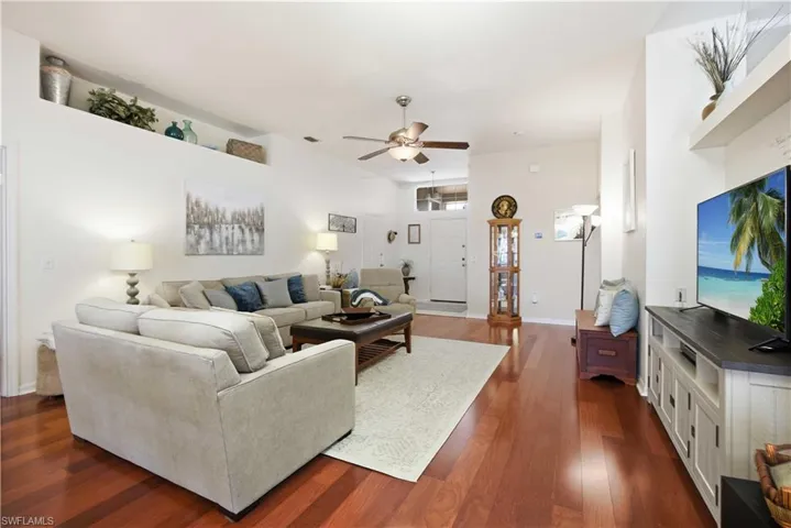 Living room with dark wood-style floors and ceiling fan