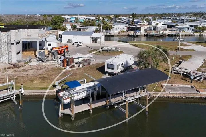 Dock area featuring boat lift, a water view, and a residential view