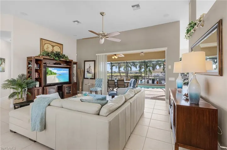 Living room with ceiling fan and light tile patterned flooring