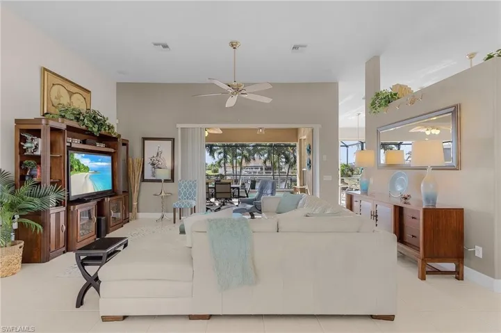 Living room with ceiling fan, plenty of natural light, and light tile patterned floors