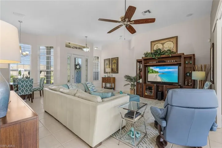 Living room featuring light tile patterned floors and ceiling fan