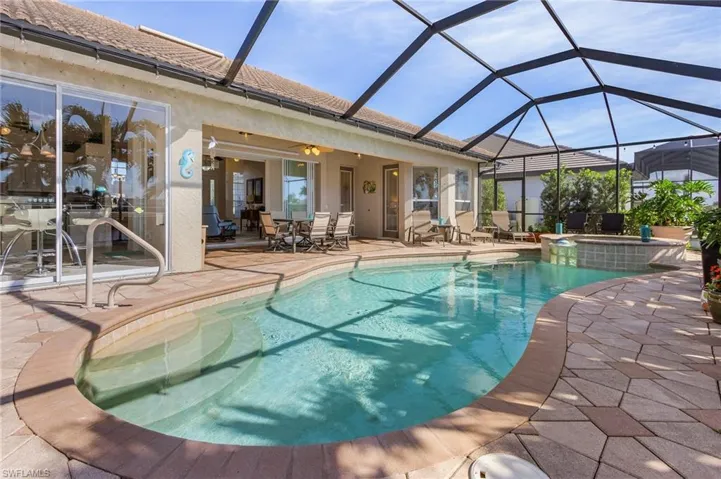 View of swimming pool with ceiling fan, a lanai, an in ground hot tub, and a patio
