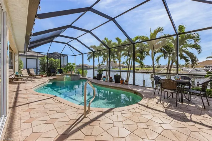 View of pool with a lanai, a water view, and a patio