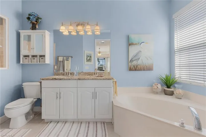 Bathroom with tile patterned floors, vanity, toilet, and a bathtub