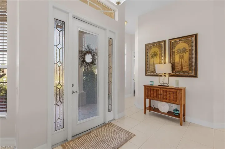 Entrance foyer with light tile patterned floors and a healthy amount of sunlight