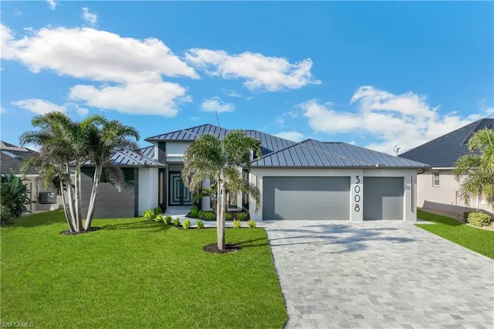 View of front of property featuring a garage and a front yard