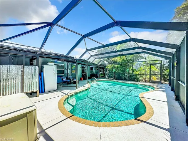 Outdoor pool featuring a patio and glass enclosure