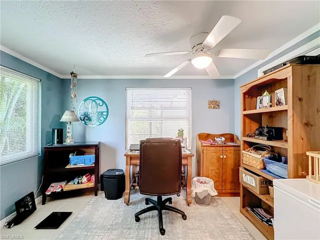 Office area featuring ornamental molding, a ceiling fan, and light tile patterned flooring