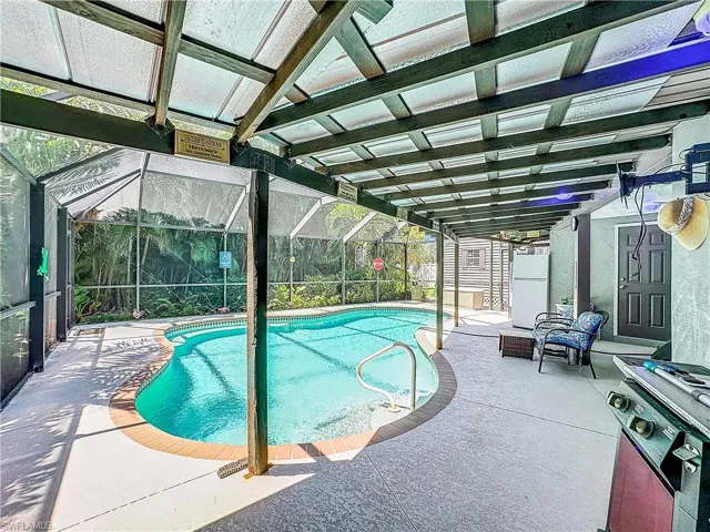 Outdoor pool featuring a patio and glass enclosure