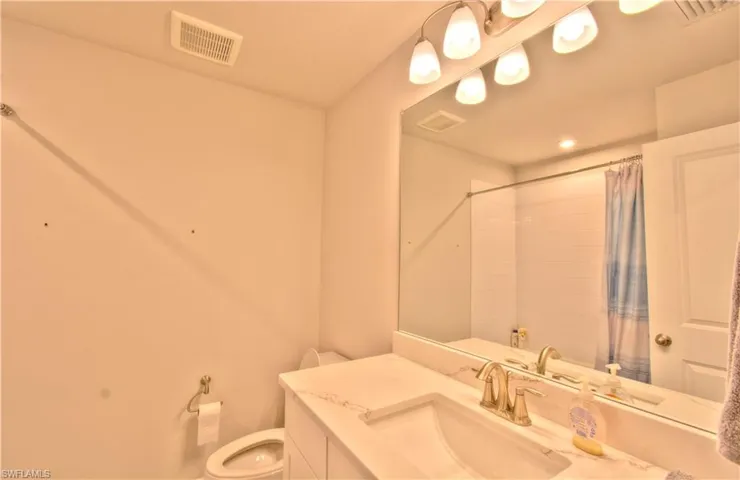 Bathroom with vanity and curtained shower