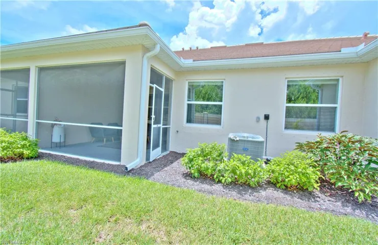 View of home's exterior featuring stucco siding, a yard, and a sunroom