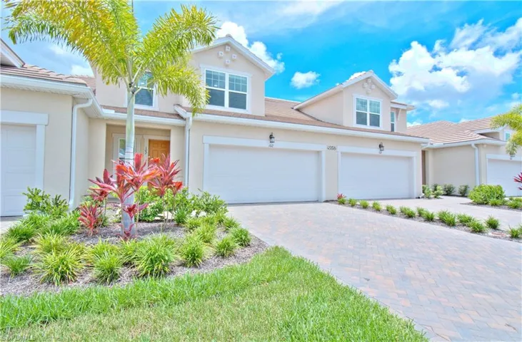 Traditional home featuring stucco siding and decorative driveway