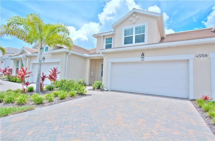View of front facade featuring stucco siding, decorative driveway, and a garage