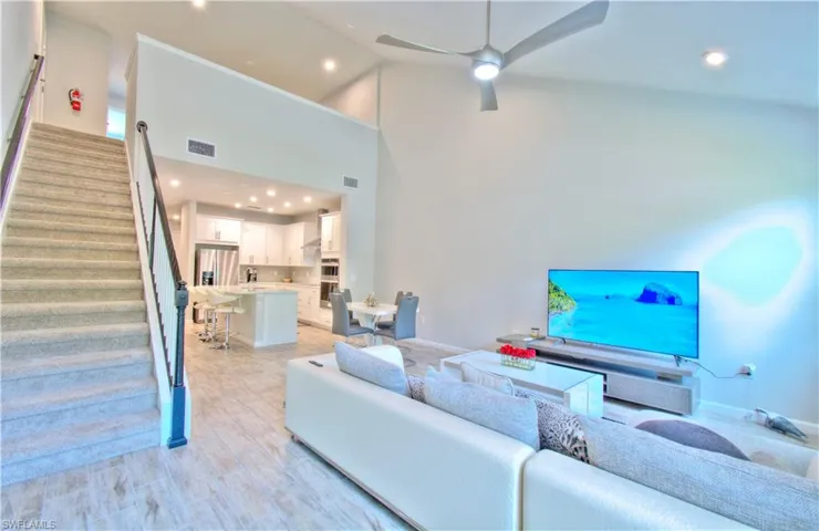 Living area featuring light wood-style flooring, recessed lighting, a ceiling fan, and lofted ceiling