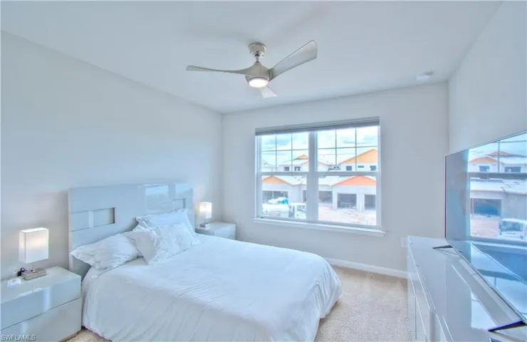 Bedroom featuring a ceiling fan and light colored carpet