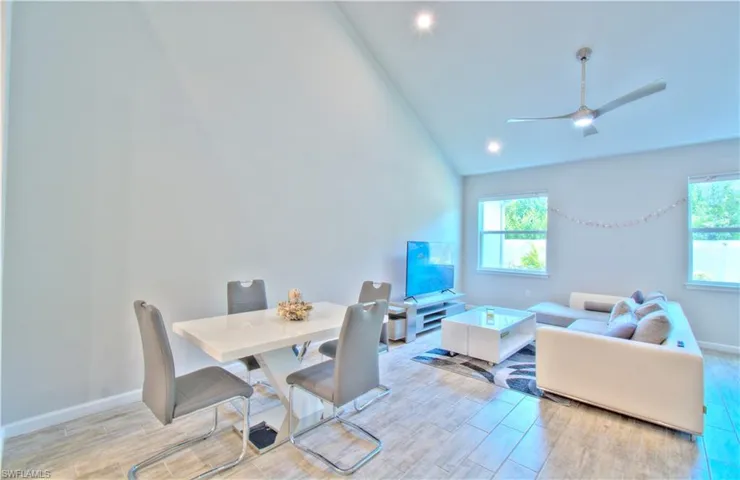 Dining space featuring wood finish floors, a ceiling fan, lofted ceiling, and recessed lighting