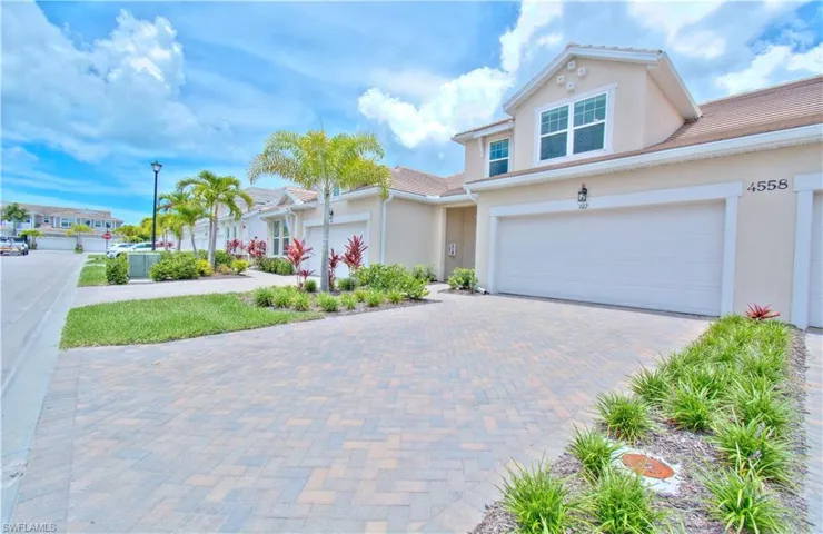 View of front of home with stucco siding and decorative driveway