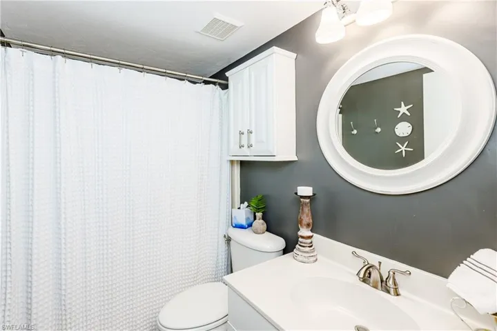 Bathroom featuring walk in shower, toilet, and vanity