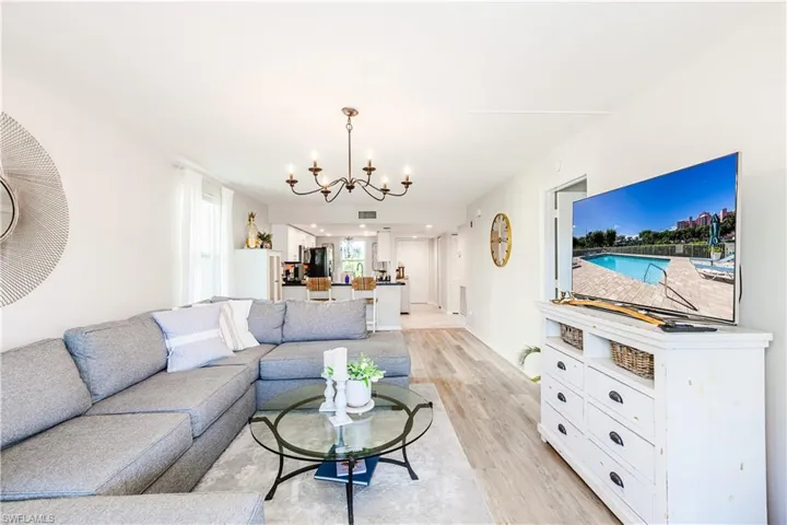 Living room with a notable chandelier and light hardwood / wood-style floors