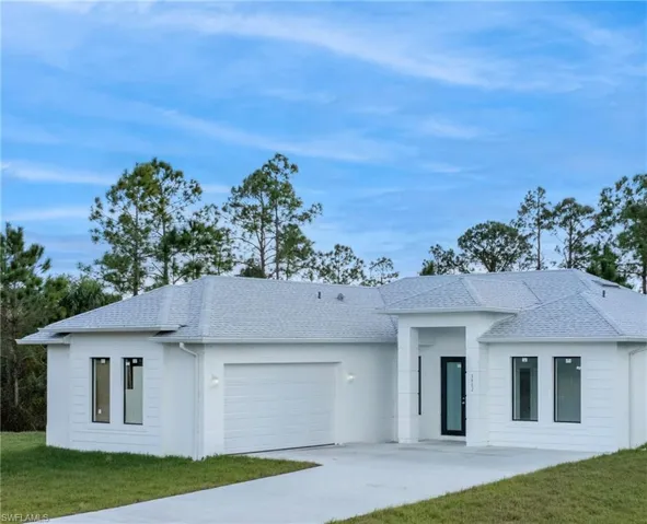 View of front of home with a garage and a front yard