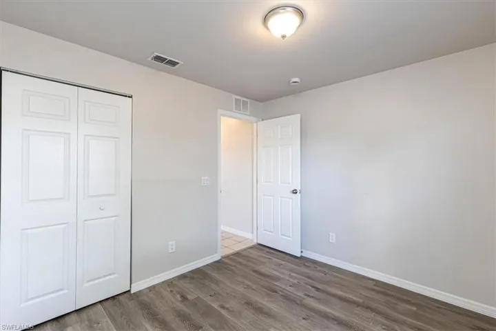 Unfurnished bedroom with wood finished floors and a closet