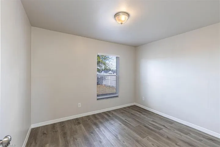Spare room with baseboards and light wood-style flooring