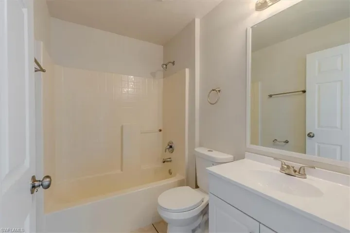 Bathroom featuring vanity, shower / bathtub combination, and light tile patterned floors