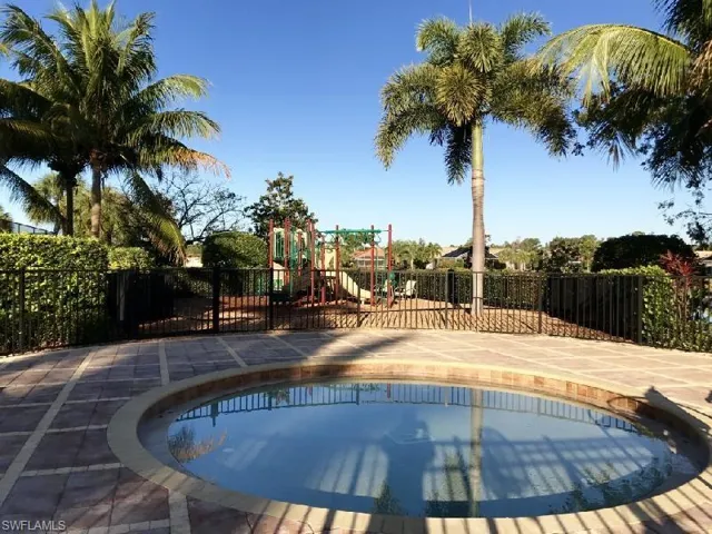View of pool featuring fence and a playground