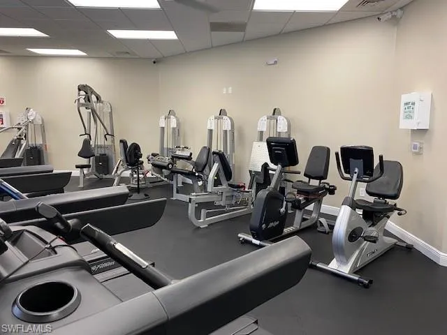 Workout area featuring a drop ceiling, visible vents, and baseboards