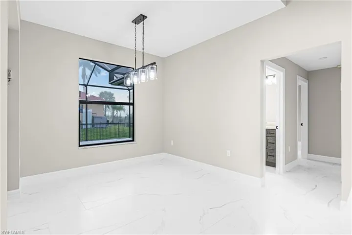 Unfurnished dining area with light marble finish flooring and a chandelier