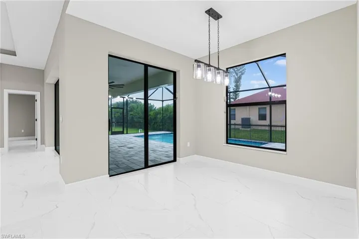 Unfurnished dining area featuring marble look tiles and a sunroom