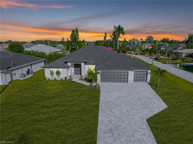 View of front of house with a front lawn, decorative driveway, a residential view, an attached garage, and roof with shingles