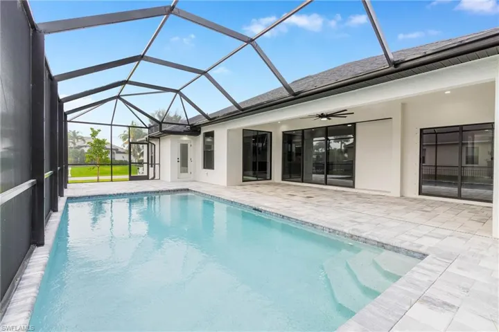 Swimming pool with a sunroom, ceiling fan, a lanai, and a patio