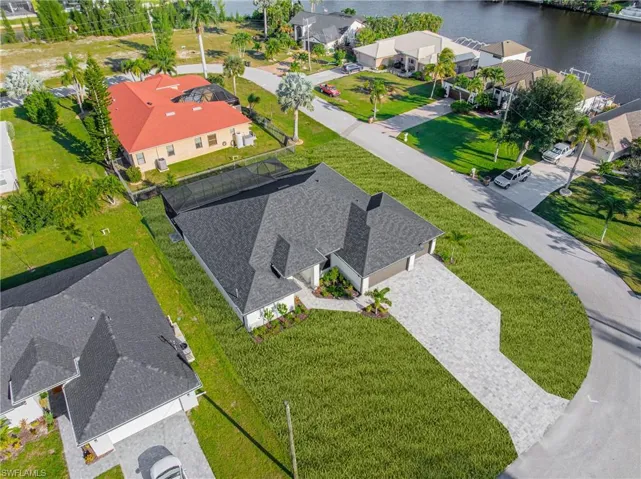 Aerial view of residential area featuring a nearby body of water