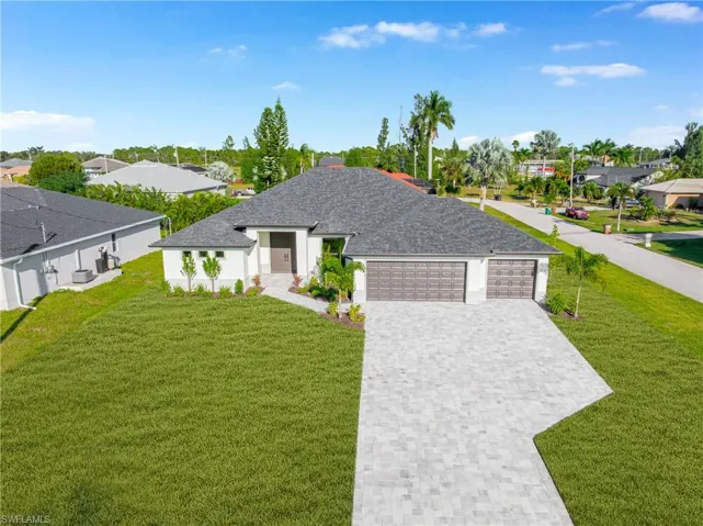 View of front of house with a residential view, a front lawn, decorative driveway, roof with shingles, and a garage