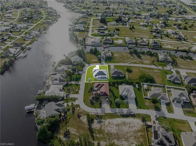 Aerial view of property and surrounding area with nearby suburban area and a large body of water