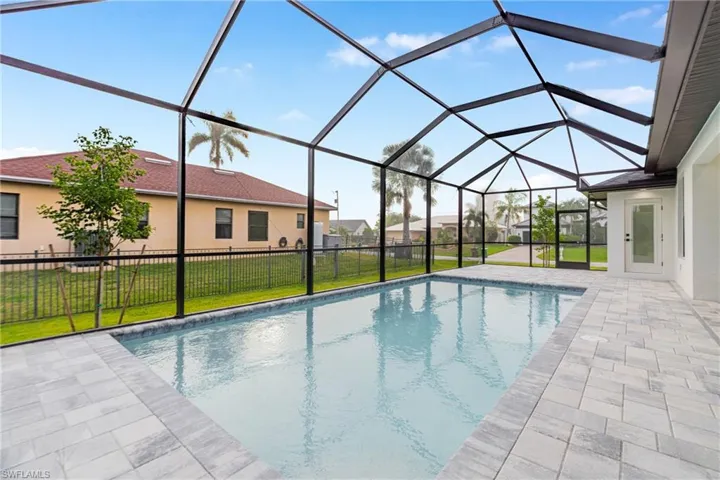 View of swimming pool with a sunroom, a patio, a lanai, and a residential view