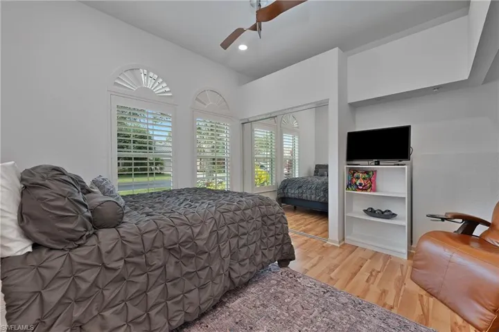 Bedroom with wood finished floors, ceiling fan, and recessed lighting